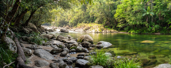 Clear forest river flowing over smooth stones